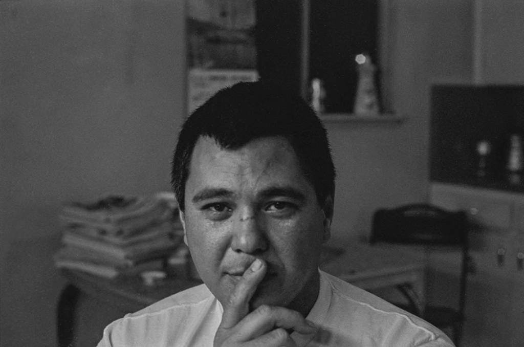 Emmon Clarke looking at the camera with pointer finger resting on his mouth.