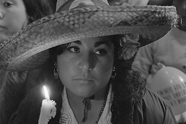 Carolina Franco holding a candle at a rally during the march to Sacramento, Modesto, CA, 1966
