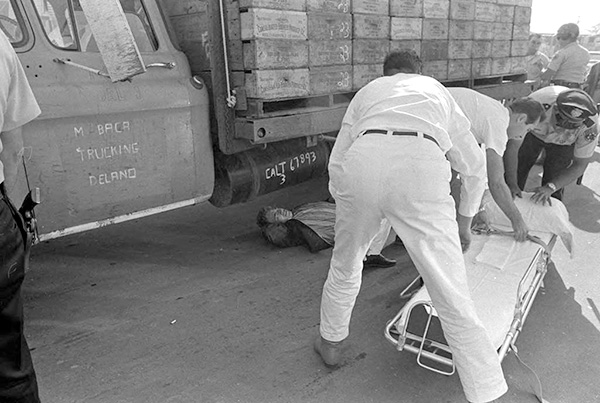 Farmworker Manuel Rivera lays injured on the ground after being run over by a truck driver in front of a packing shed. Delano, October 15, 1966. Photograph by Emmon Clarke.
