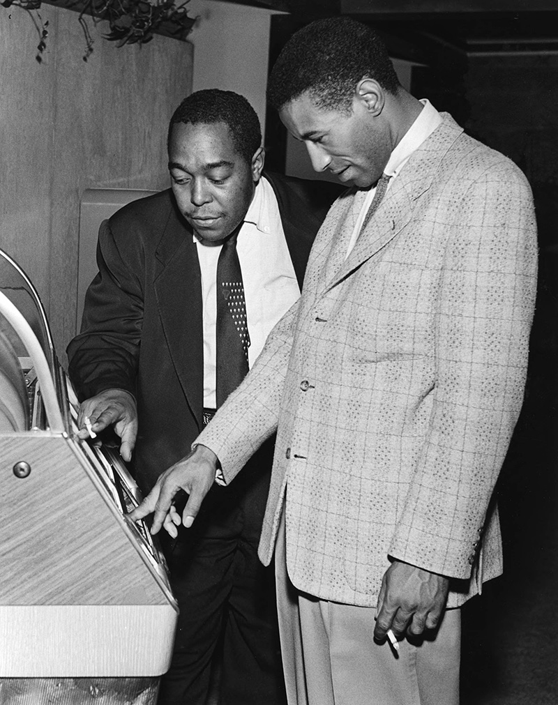 Charlie Parker and Max Roach choosing selections from a juke box, Los Angeles, 1953