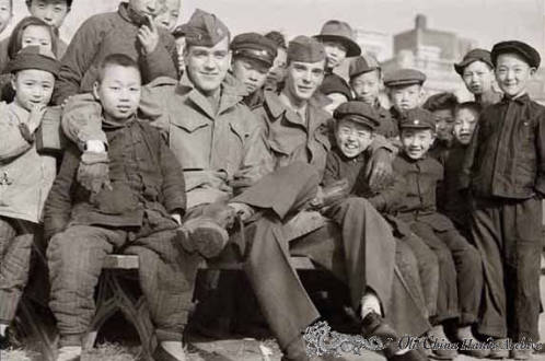 American enlisted men with a crowd of local children in Tientsin park, 1946