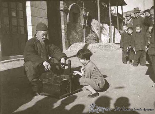 Little girl selecting candy from street vendor, spring 1946