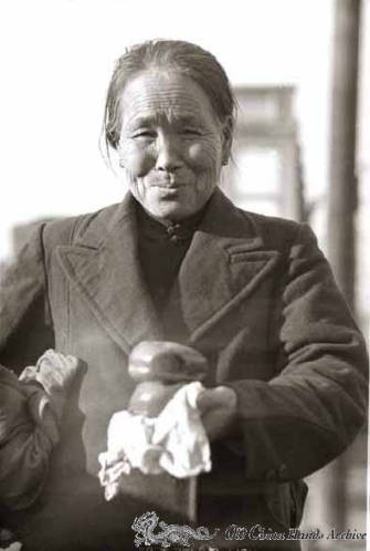 Elderly chinese woman buying steamed buns on street of Tientsin, 1946
