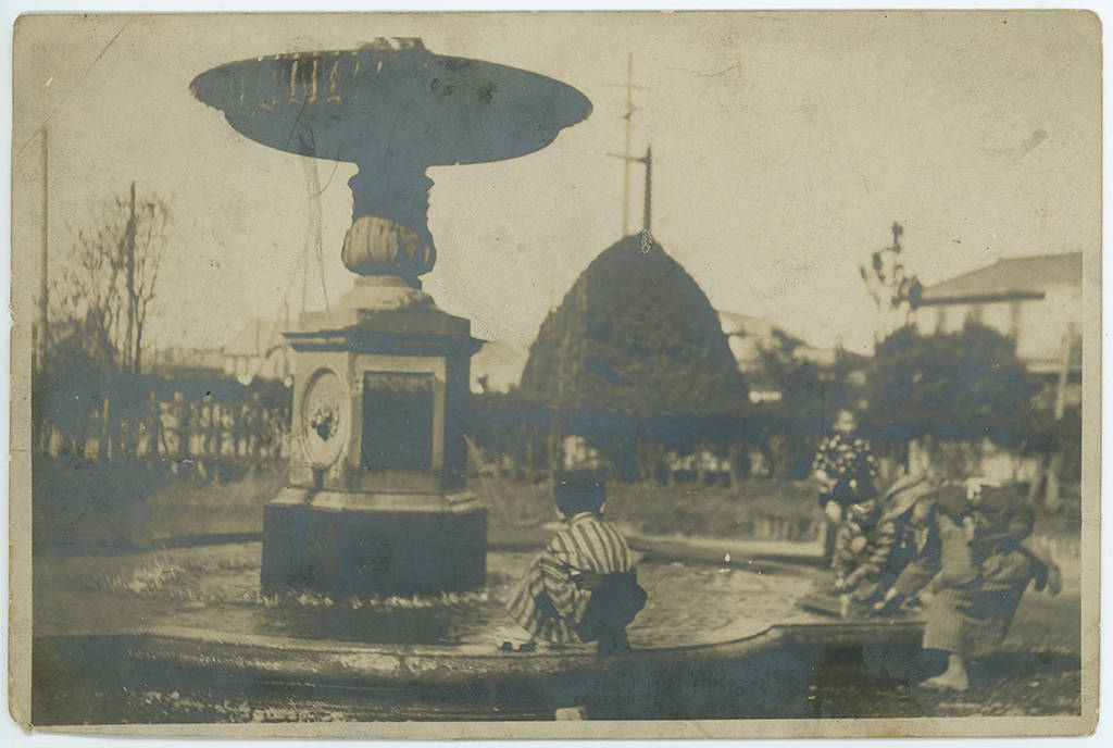 Children playing in a fountain, ca. 1910