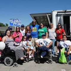 group of people holding signs and wearing t-shirts to promote disability awareness
