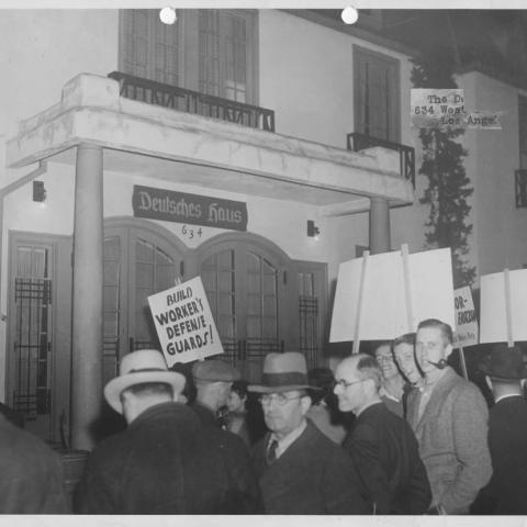 Photograph of people protesting in front of a German house