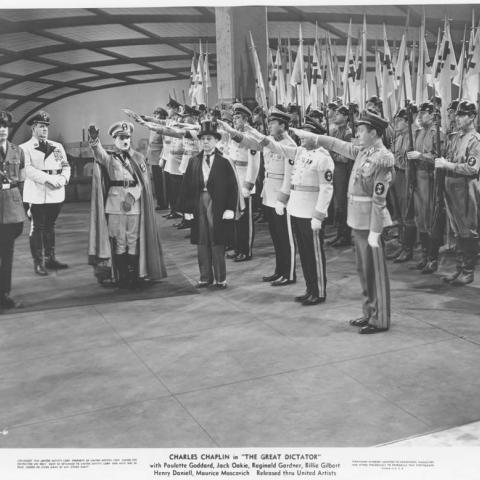 Film still showing men saluting Hitler from The Great Dictator