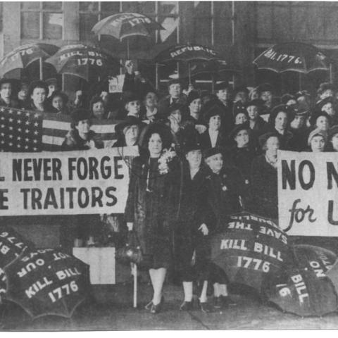 Photograph of people with signs titled We'll Never Forget the Traitors