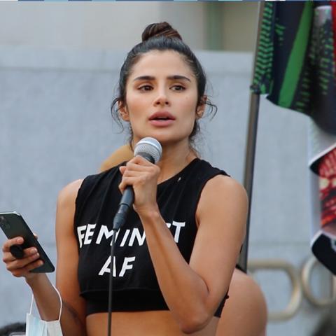 Woman speaks through handheld microphone