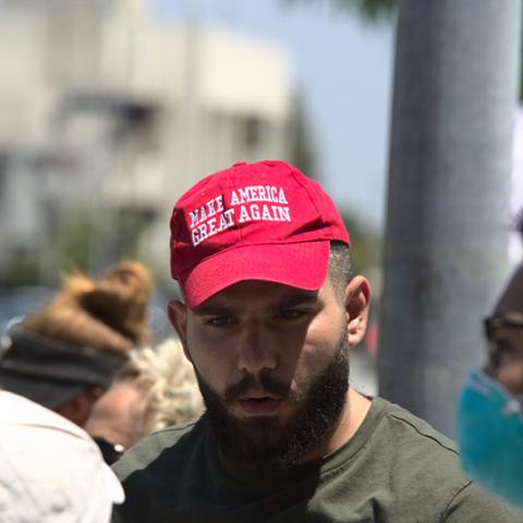  Man wearing a red hat with the campaign slogan," Make America Great Again"