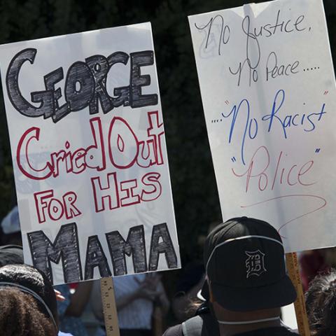 Two signs:  GEORGE Cried Out FOR HIS MAMA; No Justice, No Peace… No Racist Police