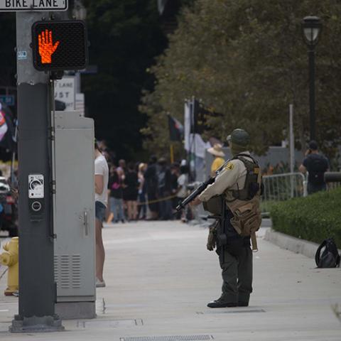 Armed officer standing on the sidewalk