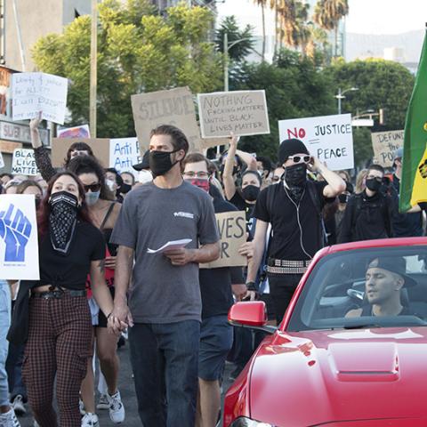  Masked protesters marching with an Ethiopian flag and signs:  BLM; NOTHING F*CKING MATTERS UNTIL BLACK LIVES MATTER; NO JUSTICE NO PEACE