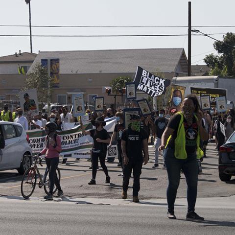 Masked marchers carrying signs including: BLACK LIVES MATTER
