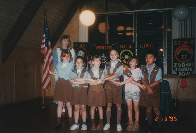 Six children facing the camera while holding hands with instructor in the background