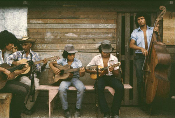 Group of musicians playing in front of a house.